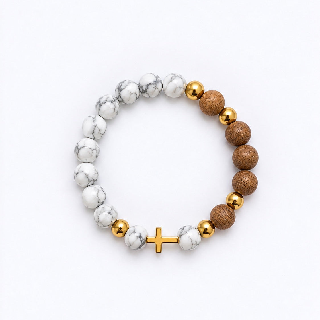 A beaded stretch bracelet featuring white and gray marbled beads, natural brown wood beads, polished gold-tone spacer beads, and a small gold-tone cross charm, displayed on a clean white background.